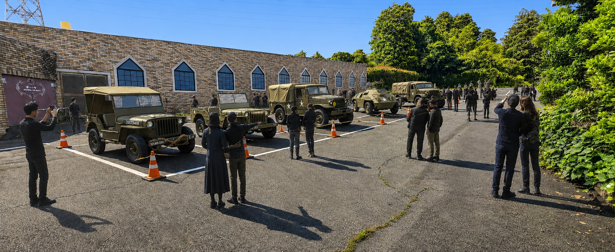 博物館の駐車場に横一列に並べられた軍用車両と、それを撮影する来場者